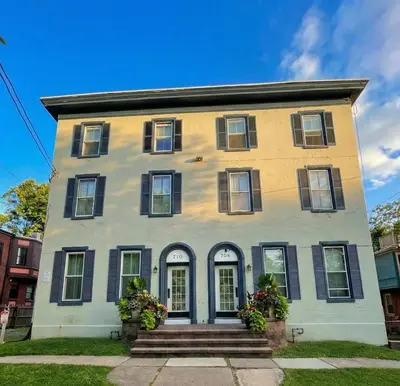 a yellow and white house with black windows at Boardwalk- large modern unit with King bed fast WIFI free coffee and easy parking in Wilmington