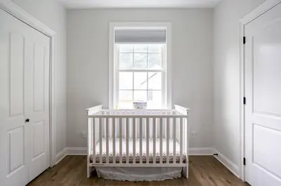 a white crib in a room with a window at Pike Creek Palace 6 Bedrooms with 5 King beds Villa in Wilmington's Chateau Country in Wilmington