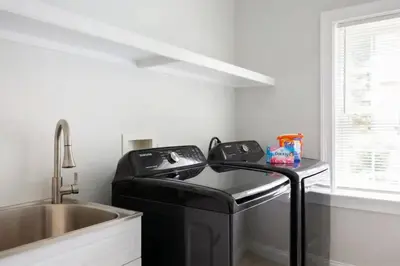 a black washer in a kitchen next to a sink at Pike Creek Palace 6 Bedrooms with 5 King beds Villa in Wilmington's Chateau Country in Wilmington
