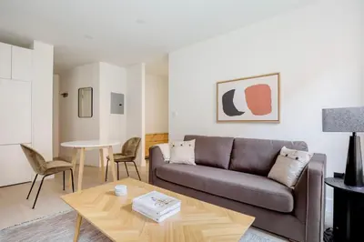 a living room with a couch and a table at Blueground Chelsea elev wd nr 8th Ave NYC-1450 in New York