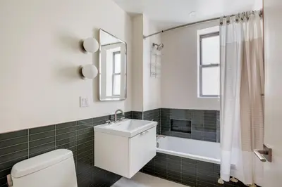 a bathroom with a toilet and a sink and a tub at Blueground Chelsea elev wd nr 8th Ave NYC-1450 in New York