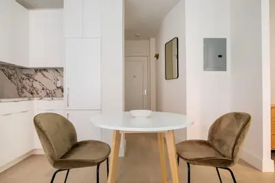a white table and two chairs in a kitchen at Blueground Chelsea elev wd nr 8th Ave NYC-1450 in New York