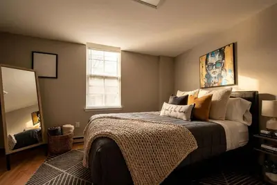a bedroom with a large bed and a mirror at The Terrace at Park Place 2nd floor walk up -cozy 2 bedroom fast WiFi free coffee in Wilmington
