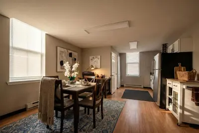 a kitchen and dining room with a table and a refrigerator at The Terrace at Park Place 2nd floor walk up -cozy 2 bedroom fast WiFi free coffee in Wilmington