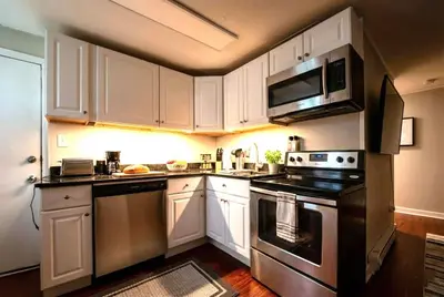 a kitchen with white cabinets and a stove top oven at Redwood loft at Park Place King bed walk in closet fast WIFI and free coffee in Wilmington