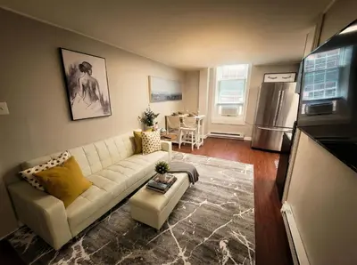 a living room with a white couch and a kitchen at Redwood loft at Park Place King bed walk in closet fast WIFI and free coffee in Wilmington
