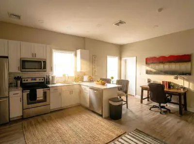 a kitchen with white cabinets and a table in it at The Penthouse at Park Place King bed fast WIFI and free coffee in Wilmington