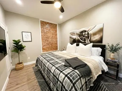 a bedroom with a bed and a brick wall at The Penthouse at Park Place King bed fast WIFI and free coffee in Wilmington