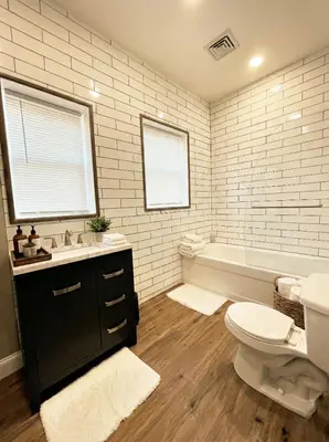 a bathroom with a toilet and a sink and a tub at The Penthouse at Park Place King bed fast WIFI and free coffee in Wilmington