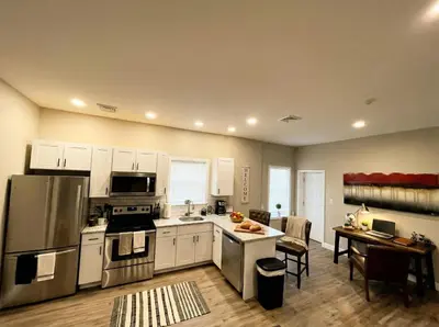 a large kitchen with white cabinets and a table with chairs at The Penthouse at Park Place King bed fast WIFI and free coffee in Wilmington