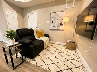 a living room with a black chair and a rug at The Penthouse at Park Place King bed fast WIFI and free coffee in Wilmington