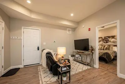 a living room with a bed and a television at The Penthouse at Park Place King bed fast WIFI and free coffee in Wilmington