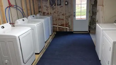 a laundry room with four washing machines in it at The Penthouse at Park Place King bed fast WIFI and free coffee in Wilmington