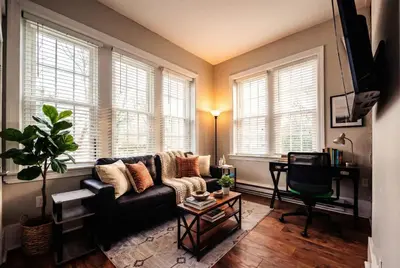 a living room with a couch and some windows at Park Place- cozy modern space fully updated fast WiFi good coffee and easy parking in Wilmington