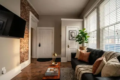 a living room with a black couch and a table at Park Place- cozy modern space fully updated fast WiFi good coffee and easy parking in Wilmington