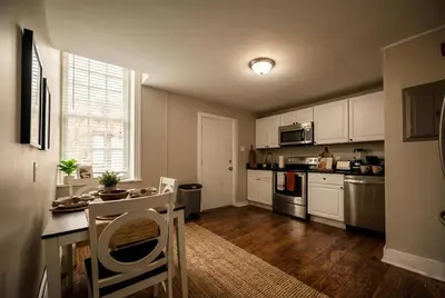 a kitchen with white cabinets and a table with chairs at Park Place- cozy modern space fully updated fast WiFi good coffee and easy parking in Wilmington