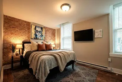 a bedroom with a bed and a brick wall at Park Place- cozy modern space fully updated fast WiFi good coffee and easy parking in Wilmington
