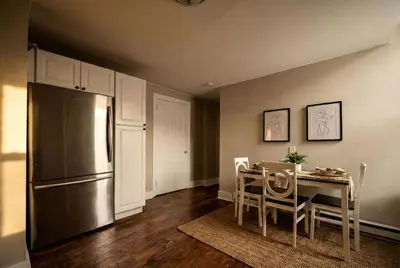 a kitchen with a table and a stainless steel refrigerator at Park Place- cozy modern space fully updated fast WiFi good coffee and easy parking in Wilmington