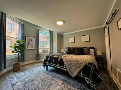 a bedroom with a bed and a large window at The Grayson at Park Place- cozy and fully updated with King bed free coffee and fast WIFI in Wilmington