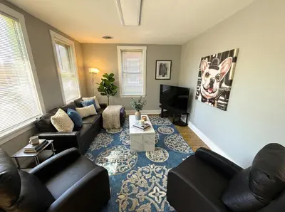 a living room with couches and a tv at Cozy Walk up King Bed fast WiFi in Wilmington