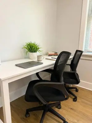 an office desk with two chairs and a laptop at Cozy Walk up King Bed fast WiFi in Wilmington