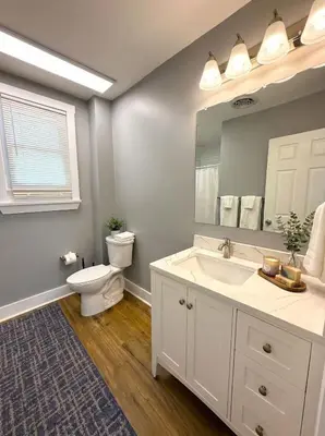 a bathroom with a sink and a toilet and a mirror at Cozy Walk up King Bed fast WiFi in Wilmington