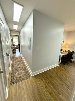 an empty hallway with a white wall and a desk at Cozy Walk up King Bed fast WiFi in Wilmington