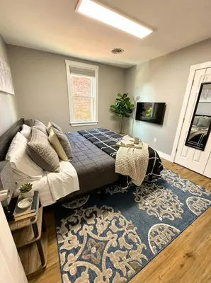 a bedroom with a large bed and a blue rug at Cozy Walk up King Bed fast WiFi in Wilmington