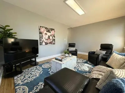 a living room with a couch and a flat screen tv at Cozy Walk up King Bed fast WiFi in Wilmington