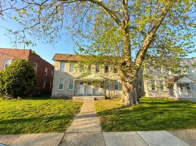 a house with a tree in the front yard at Cozy unit King bed & laundry in Wilmington