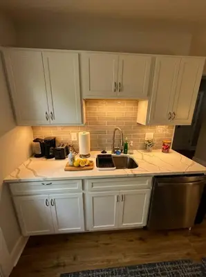 a kitchen with white cabinets and a sink at Cozy unit King bed & laundry in Wilmington