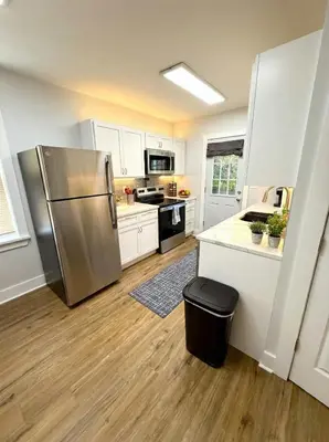 a kitchen with a stainless steel refrigerator and white cabinets at Cozy unit King bed & laundry in Wilmington