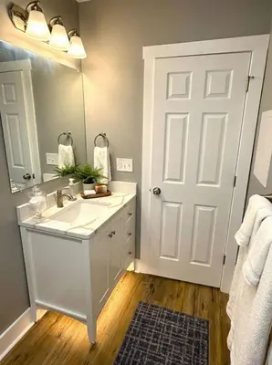 a white bathroom with a sink and a mirror at Cozy unit King bed & laundry in Wilmington