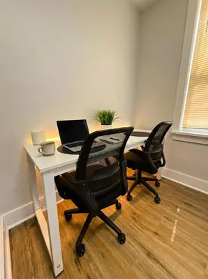 an office with a desk with a laptop and two chairs at Cozy unit King bed & laundry in Wilmington