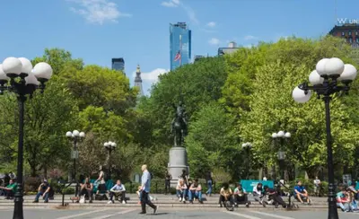 a group of people sitting on benches in a park at Oasis Apartment in the Heart of Union Square Downtown Manhattan in New York