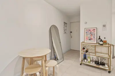 a room with a table and a surfboard on the wall at Oasis Apartment in the Heart of Union Square Downtown Manhattan in New York
