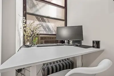 a desk with a computer and a window at Heart of Downtown Manhattan - Stylish One Bedroom Apartment in Vibrant Union Square in New York