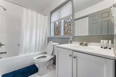 a white bathroom with a toilet and a sink at Gorgeous 5BD w Hot-Tub & Pool villa located in the middle of Pocono in East Stroudsburg