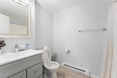 a bathroom with a toilet and a sink and a mirror at Gorgeous 5BD w Hot-Tub & Pool villa located in the middle of Pocono in East Stroudsburg