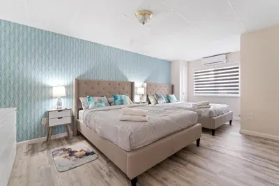 two beds in a bedroom with blue walls at Gorgeous 5BD w Hot-Tub & Pool villa located in the middle of Pocono in East Stroudsburg