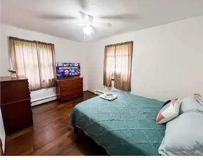 a bedroom with a green bed and a television at Cozy Palace in Livingston Manor