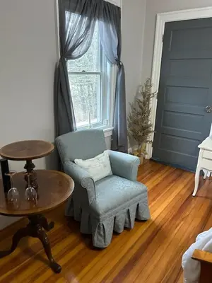 a living room with a chair and a table and a window at 37 Oak Ridge House in Wellsboro