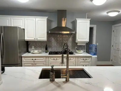 a kitchen with white cabinets and a sink at 37 Oak Ridge House in Wellsboro