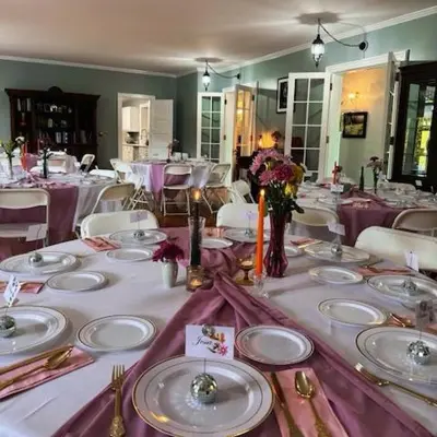a dining room with a table with plates and flowers at 37 Oak Ridge House in Wellsboro