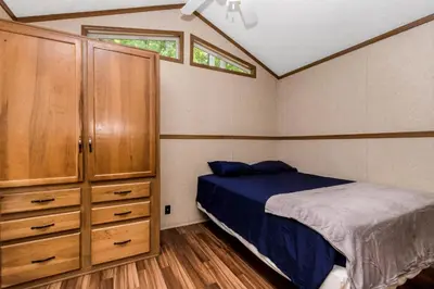 a bedroom with a bed and a dresser at Jellystone Park Birchwood Acres in Greenfield Park
