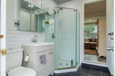 a bathroom with a toilet and a glass shower at A home away from home in Hightstown