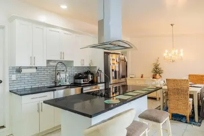 a kitchen with white cabinets and a black counter top at A home away from home in Hightstown