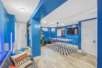 a play room with blue walls and a ping pong table at Newark's Family Favorite Place in Newark