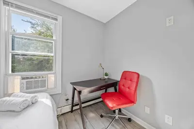 a bedroom with a red chair and a desk at Newark's Family Favorite Place in Newark