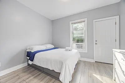a white bedroom with a bed and a window at Newark's Family Favorite Place in Newark